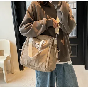 Borsa tote kaki con toppa a orso e coulisse indossata con una felpa con cappuccio