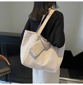 Detail of woven tote bag in oatmeal beige with matching coin purse and wide strap