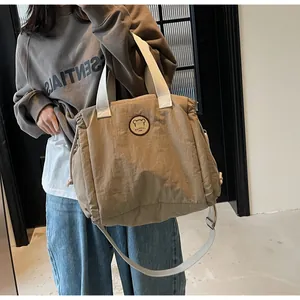 Dettaglio della borsa tote in nylon kaki con coulisse e toppa con logo orso