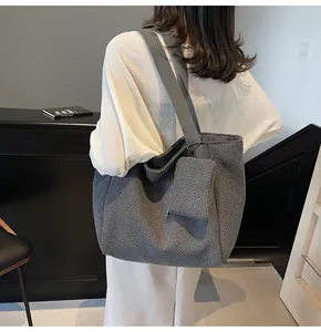 Detail of grey woven tote bag set featuring fine grid pattern and adjustable strap