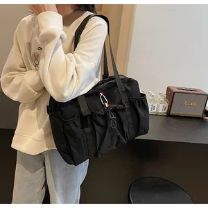 Detail einer großen schwarzen Nylontasche mit Seitentaschen und Kordelzug-Design
