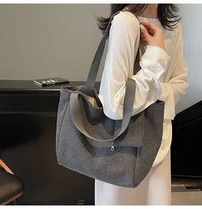 Close-up of a large houndstooth woven tote bag showing dual straps for versatile use