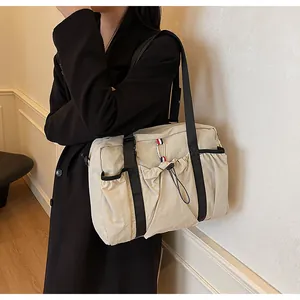 Detail der cremefarbenen Nylontasche mit Kordelzug und gestreiftem Gurtband für Damen