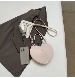 Detailed top view of a pink heart-shaped bag with adjustable straps and PU leather texture