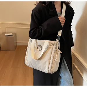 Dettaglio borsa a tracolla trapuntata beige con toppa orso e tracolla regolabile