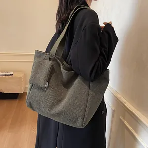 Olive green houndstooth woven tote bag with small zipper pouch shown on shoulder