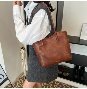 Close-up of brown leather tote bag showing vintage texture and gold FASHION & BAGS logo