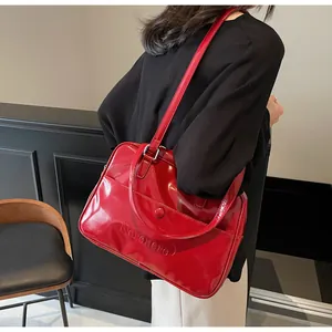 Dettaglio della borsa a spalla rossa lucida con scritta a rilievo e anello in metallo