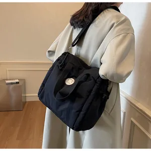 Dettaglio borsa tote in nylon trapuntato nero con toppa a forma di orso e chiusura a coulisse