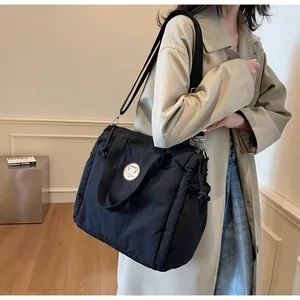 Dettaglio della borsa shopper trapuntata nera con toppa fashion e design con coulisse