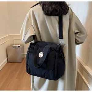 Borsa tote trapuntata in nylon nero con icona orso indossata da modella in interni