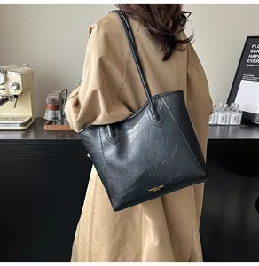 Close-up of black PU leather tote bag with crinkled texture and golden fashion lettering