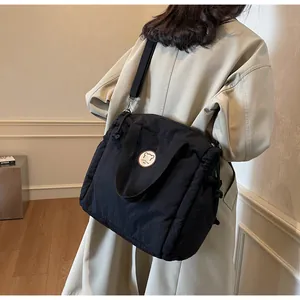 Dettaglio della borsa tote nera trapuntata con logo orso e tracolla regolabile versatile