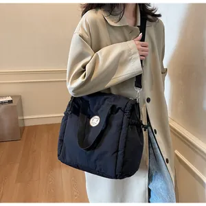 Dettaglio borsa tote in nylon trapuntato nero con patch orsetto e chiusura a coulisse