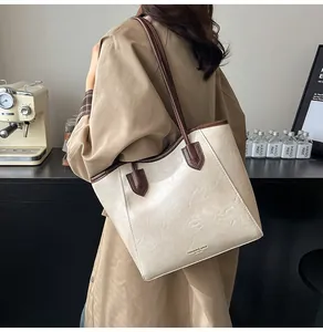 Detailed side view of large cream and brown contrast tote bag with pleated leather texture