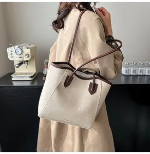 Macro view of textured cream PU leather tote with brown straps and zipper detail