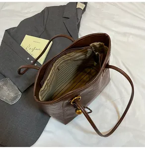 Interior view of brown tote bag with striped lining and multiple compartments