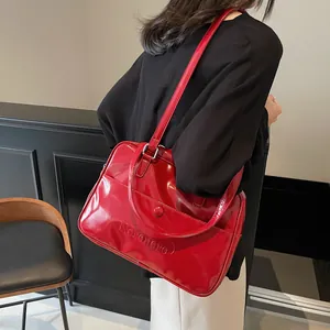 Borsa tote vintage rossa lucida in similpelle con logo Nornom indossata dalla modella