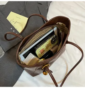 Top view of spacious interior of brown tote bag showing compartments and daily essentials