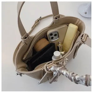 Interior view showing the spacious capacity of this khaki leather bucket bag for women