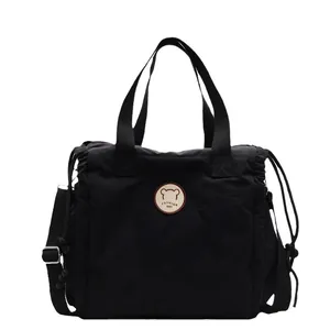 Borsa a tracolla versatile in tela nera con lati a coulisse e dettaglio logo orso