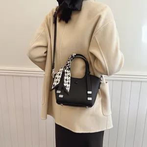 Chic black bucket bag with houndstooth silk scarf handle and leather crossbody strap