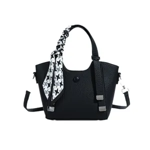 Black pebbled leather bucket bag with houndstooth scarf handle on a white background