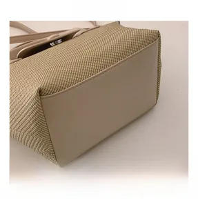 Detail view of the French-style dumpling bag showing beige leather base and stitching
