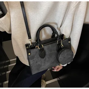 Detail of dark grey tote bag with mini round pouch and adjustable crossbody strap