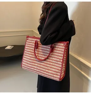 Detail of red houndstooth tote bag showing large capacity and leather shoulder straps