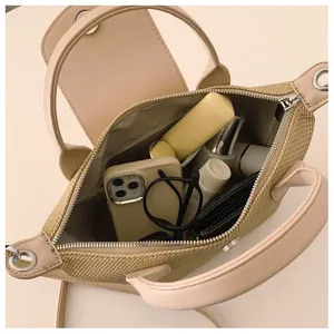 Detail view of woven straw handbag interior showing ample space for phone and makeup