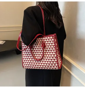 Red and white houndstooth tote bag with leather handles shown on a model from the back