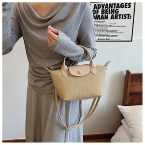Detailed macro view of French style woven straw bag with beige leather trim and strap