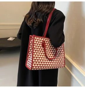 Detail of red and cream heart jacquard fabric tote bag with leather straps and handles