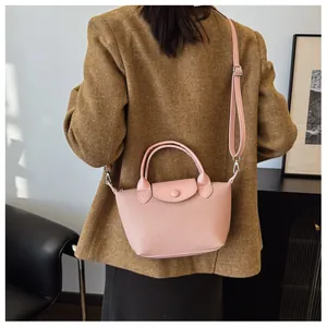 Pink woven texture dumpling bag shown on model back view in a minimalist chic outfit
