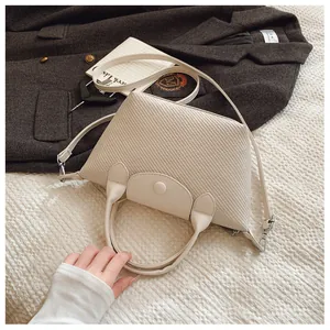 Detail of cream woven leather crossbody bag with elegant texture on a lifestyle setting