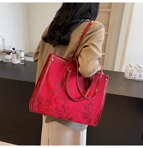Detail of red houndstooth tote bag with floral jacquard texture and leather straps