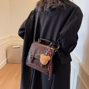 Bolso bandolera clásico de cuero marrón oscuro con colgante de oso y pañuelo retro
