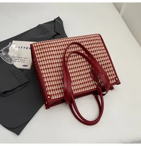 Detail of red houndstooth fabric texture and leather handles on bridal tote bag