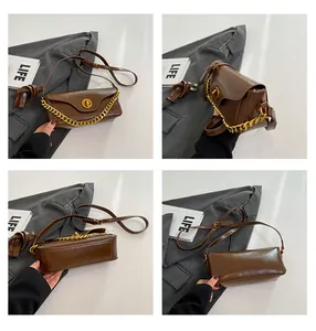 Detail view of brown leather bag featuring golden twist lock and thick chain strap
