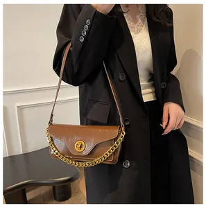 Brown glossy leather underarm bag featuring a vintage pleated texture and gold chain detail