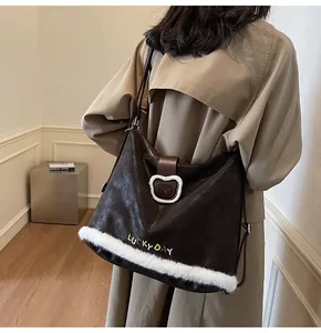 Detail of a brown tote bag with bear motif, plush white trim, and metal strap buckle