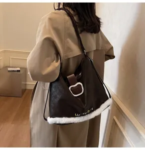 Detail of dark brown tote bag with white plush trim and Lucky Day bear patch