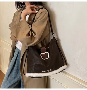 Detail of a brown leather tote with plush trim and LUCKY DAY embroidery on the bag