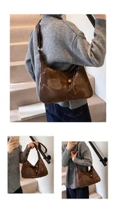 Detail of dark brown glossy shoulder bag with marble texture and golden metal ball lock
