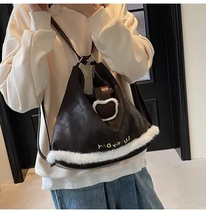 Detail of hobo bag with fuzzy white trim and cute bear patch worn on shoulder