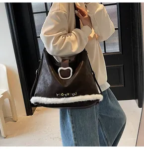Detail of dark brown tote bag featuring plush white fur trim and bear-shaped buckle