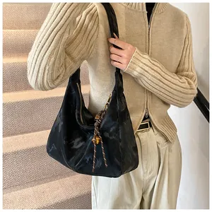 Close-up of black hobo bag with marble texture and braided rope pendant detail