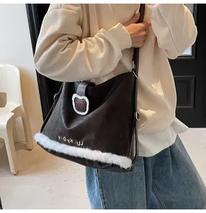 Detail of dark brown leather tote featuring white faux fur trim and bear badge embroidery