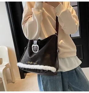 Detail showing deep brown leather tote bag with white plush trim and bear emblem design